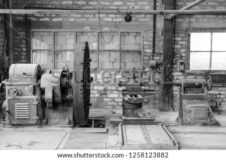 Industrial lathe of the first half of the 20th century. The workshop is located in an old mercury mine, now a museum, in Abbadia San Salvatore, in Italy. Black and white picture.