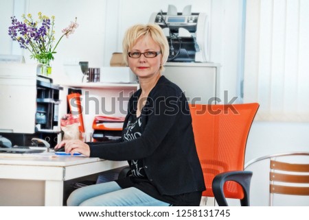 Middle-aged pretty business woman working in office