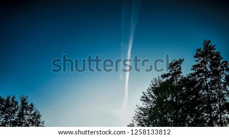 Beautiful landscape with objects. Beautiful view and background of panoramic blue sky with trees and reverse track of a flying plane.