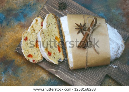 Christmas Stollen. Traditional Sweet Fruit Loaf with Icing Sugar on colorful background.Copy space 