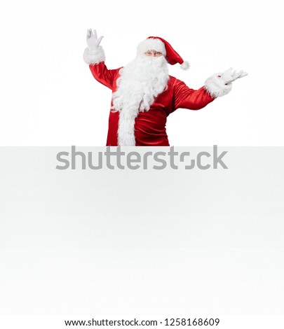 Happy Santa Claus jumping from behind the blank banner isolated on white background with copy space