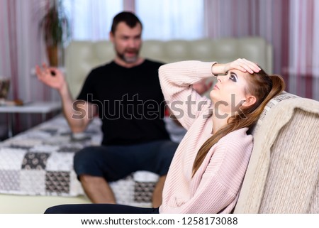 daughter and father sit in a room and quarrel