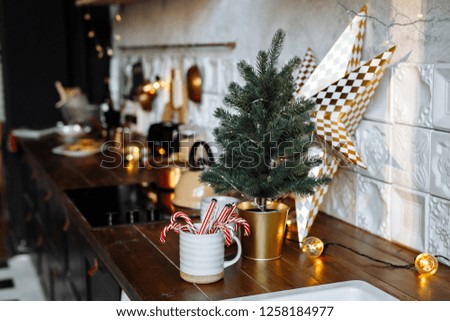 Festive Christmas kitchen decor with garlands and a small decorative Christmas tree