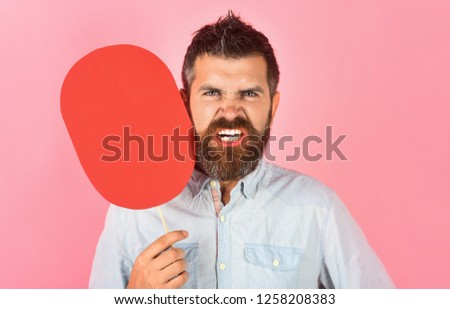 Angry bearded man hold paper nameplate. Feeling&emotions. Face expression. Fashion, beauty, hairdressing, barber salon. Wrathful man with beard&mustache. Red blank paper. Evil man with empty name card