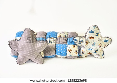 wo five-pointed star shaped pillows, patchwork comforter and knitted padded stool on white background