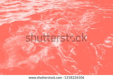 Trendy photography of the actual colors for this season - a shade of orange, coral. Beautiful pure water and a swimming pool background. Color of the year 2019. Image
