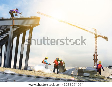 construction worker to roofing on high places of large building in construction site  Royalty-Free Stock Photo #1258274074