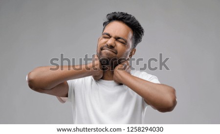 people and health problem concept - tired indian man suffering from neck pain over grey background