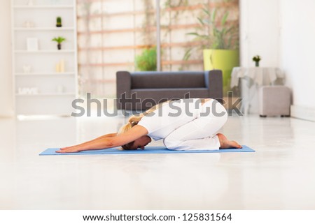 senior woman doing yoga at home