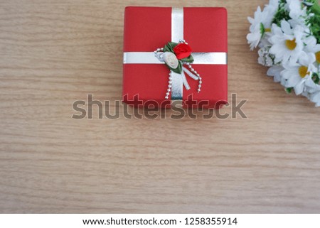 Red gift box for all festivities on wooden background. valentine,christmas, birthday and happy new year