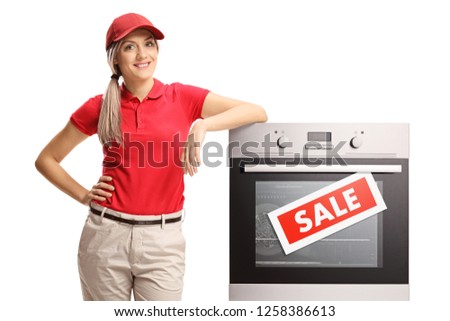 Female sales manager standing next to an electrcal oven on sale isolated on white background