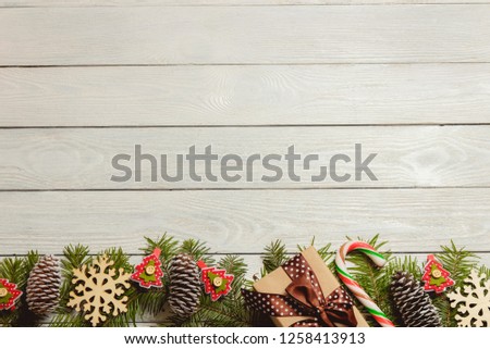 White wooden christmas background with fir branches, cones, decor, top view, copyspace.