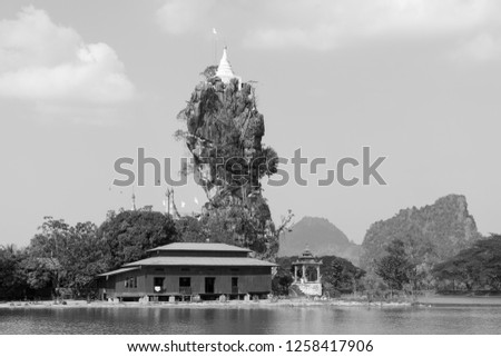 Black and white picture of Kyaut Ka Latt Pagoda built over the cliff in Hpa An, Myanmar