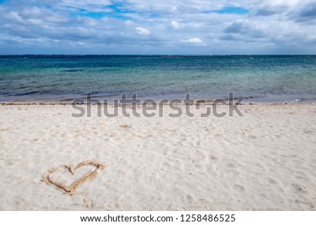 heart drawn in the sand of a beach 