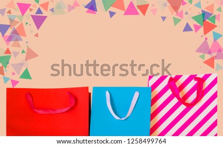 Colourful paper shopping bags on pastel background. View with copy space.