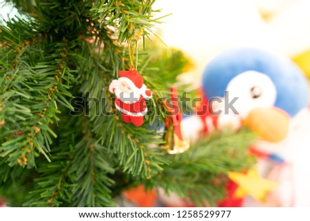 santa claus doll on green chrismas tree and blured blackground
