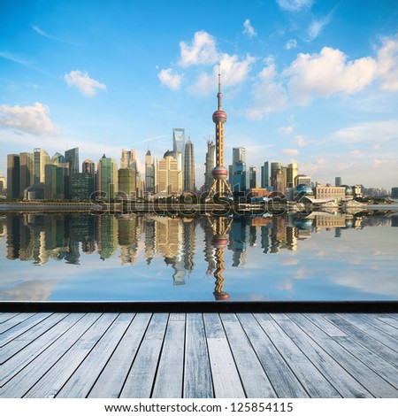 shanghai skyline in afternoon and reflection with wooden floor