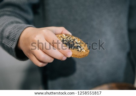 cookies with poppy seeds in the boy's hand