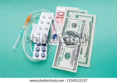 American dollars and euros with a dropper and pills. Concept expensive cancer treatment