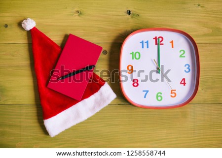 Image of Santa Hat,personal organizer and clock showing midnight wooden table.Toned image.