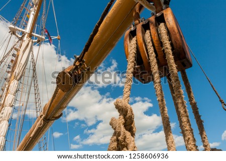 Pulley on a large sailing ship in front of vivid blue sky with white clouds Royalty-Free Stock Photo #1258606936