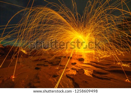 
cool burning steel wool art fire work photo experiments on the beach at sunset