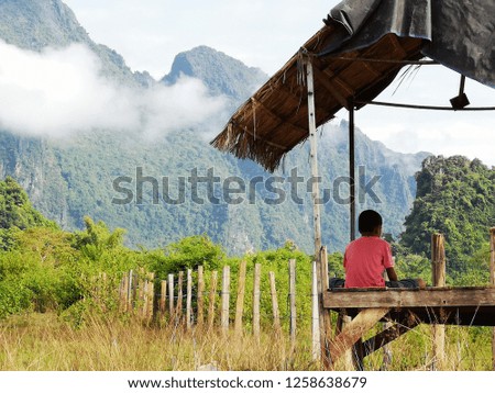 Young boy relax at cottage on mountain and blue sky with cloud background.