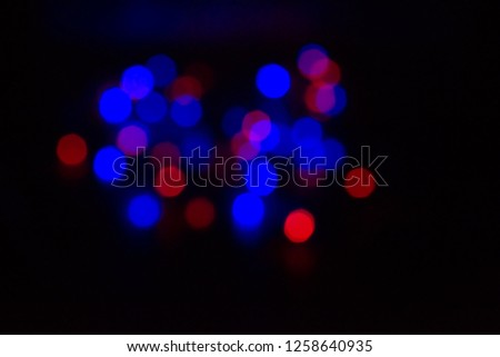 many multicolored blurry lights red, blue, glowing in the dark, black background, bokeh effect, new year