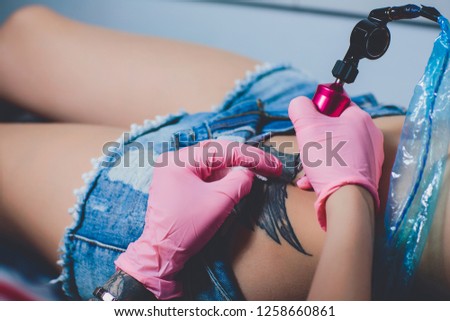 tattoo artist, tattoo on her belly, pink typewriter, specialist in pink gloves, white background.