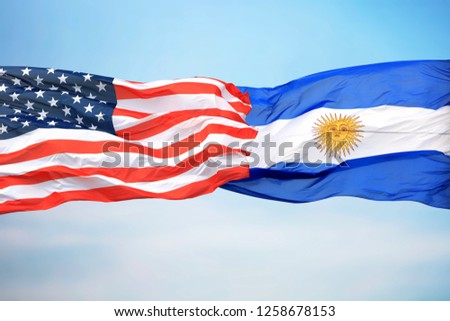 Flags of the USA and Argentina against the background of the blue sky