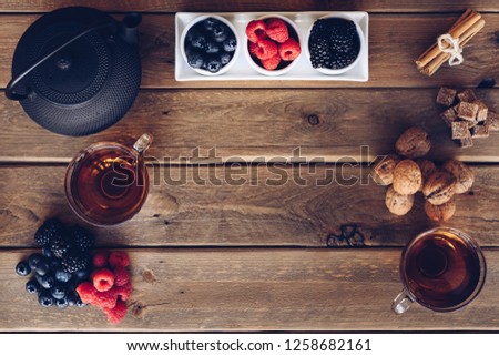 Flat lay of Cup of te and iron with dried fruit tea, cinnamon and fruits of the forest. vintage style