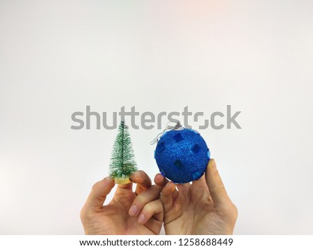 little Christmas tree and Christmas toy in hands on a white background.HD.