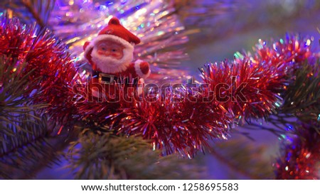 Toy Santa Claus on the branch of the Christmas tree
