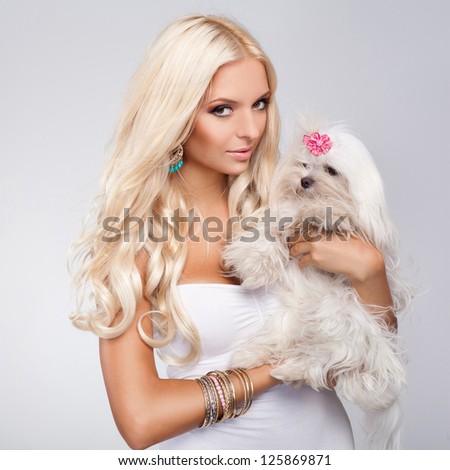 Beautiful Young Woman with Long Blonde Hair holding small dog