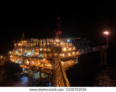 Offshore living quarter with flare tower at night time or The large offshore oil rig at night with twilight or black night background