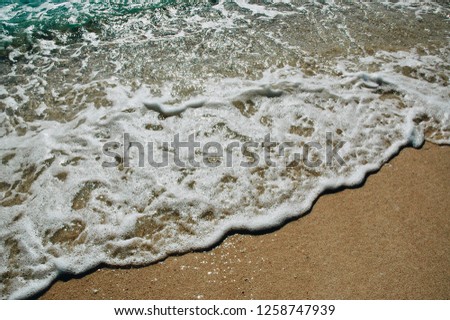 Soft Wave Of Blue Ocean On Sandy Beach. Background. Selective focus. Sea Beach and Soft wave of blue ocean. Summer day and sandy beach background. 