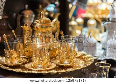 Traditional Turkish Tea sets at Grand Bazaar in Istanbul, Turkey. Golden color teapot and Turkish tea cups.
