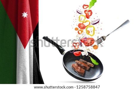 Frying pan with falling vegetables and meat, isolated objects. On the background of the flag of Jordan