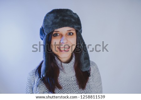 Emotional portrait of a girl, shooting in a photo Studio using a blue filter, Street style clothing hat and sweater
