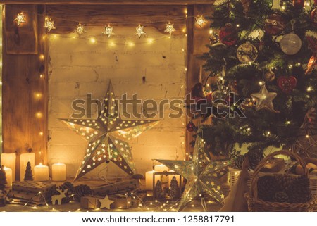 Beautiful wood mantelpiece, lit up Christmas tree with baubles and ornaments, wooden decorations, silver star, icicle lights, toned, selective focus