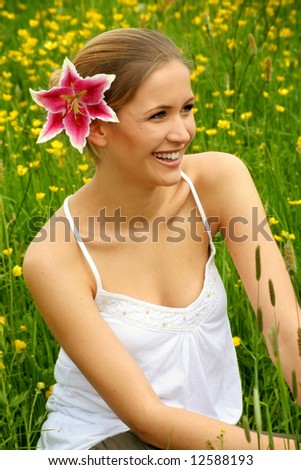 happy woman with a flower in her hair on a meadow