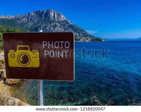 Picture of Adriatic sea with a sign that says "PHOTO POINT"