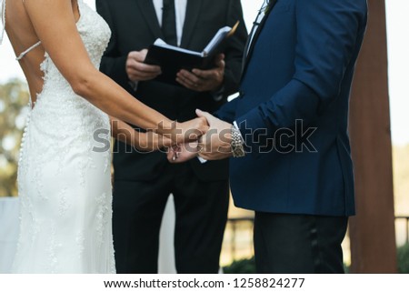 Bride and groom at ceremony outdoors, facing each other.  Royalty-Free Stock Photo #1258824277