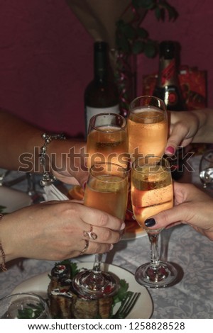 Ringing glasses of champagne in the hands of the holiday