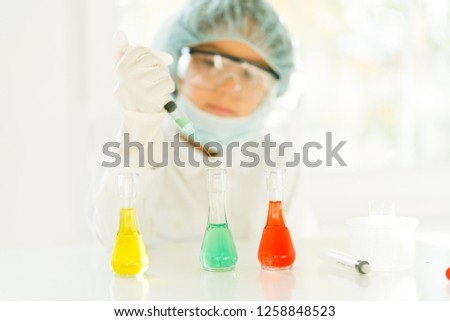 A cute boy with conical flasks in the laboratory