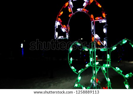 Soft glowing Christmas lights in the shape of a candy cane over a thick layer of snow
