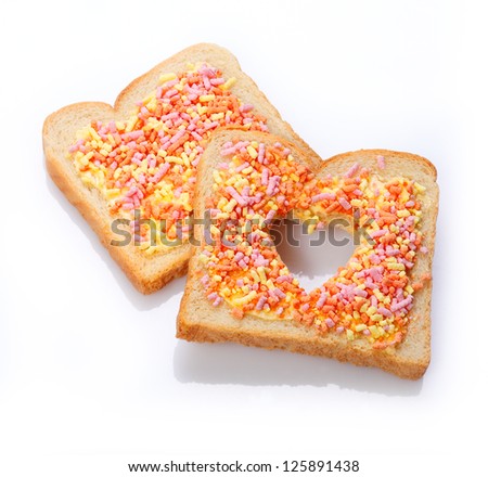 Elegant dessert made of slices of bread with candies having cut the shape of a heart