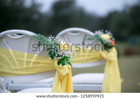 Wedding Ceremony Isle With White Chairs draped with Yellow Bows and Ribbons