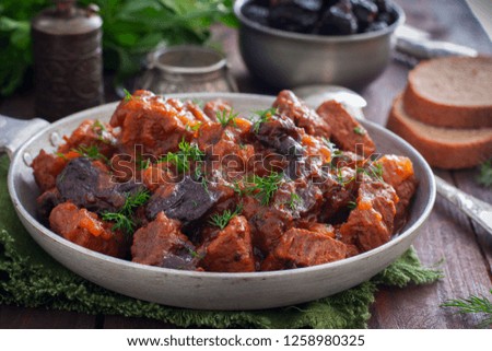 Beef with prunes in tomato sauce in a pan, horizontal