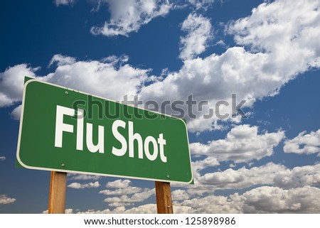 Flu Shot Green Road Sign Over Clouds and Sky.